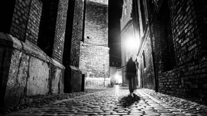 Illuminated cobbled street in old city by night