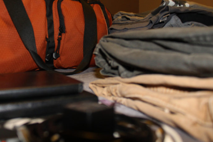 Neatly Folded Clothes in front of Orange Duffle Bag