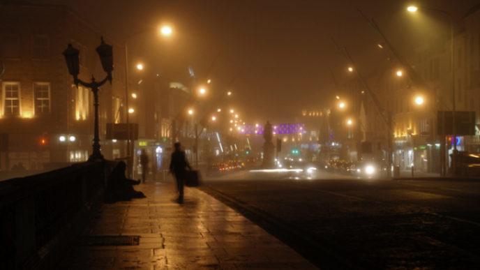 Solitary figure on bridge in Cork by night, Ireland