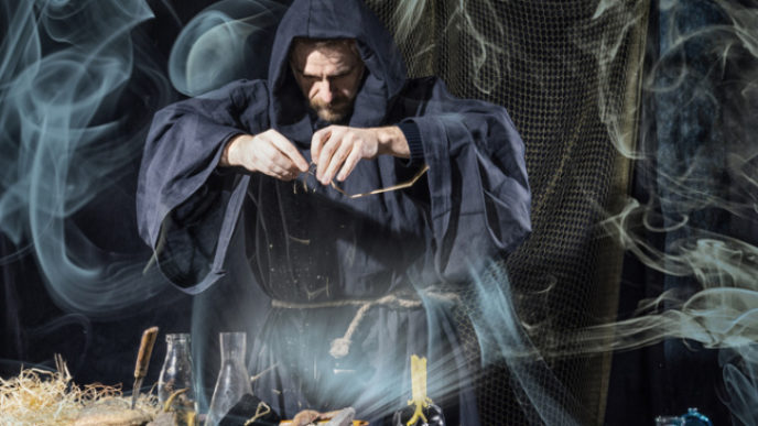 Halloween. The medieval alchemist holds magic ritual smoke