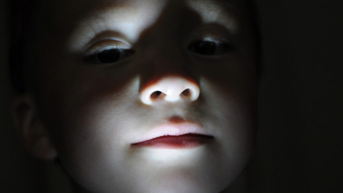 Little boy portrait in the dark making horror