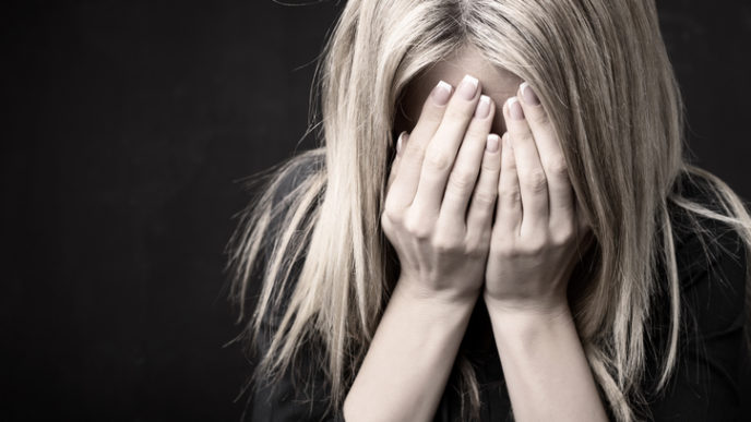Close up of woman holding her face in her hands