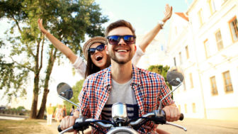 Couple in love riding a motorbike , Handsome guy and young sexy woman travel . Young riders enjoying themselves on trip. Adventure and vacations concept.