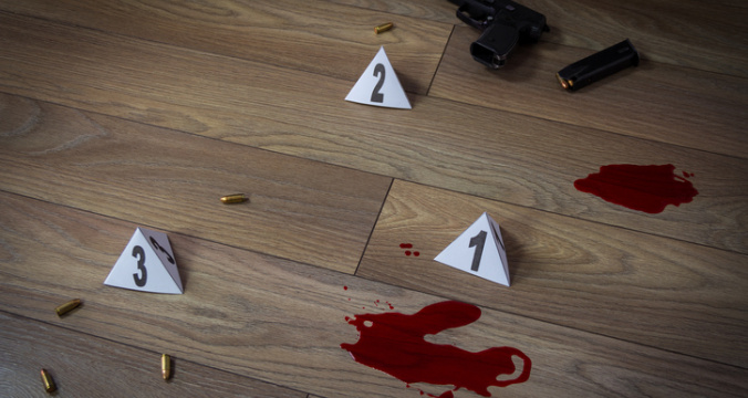 Crime scene indoors with traces of blood, handgun pistol and bullets