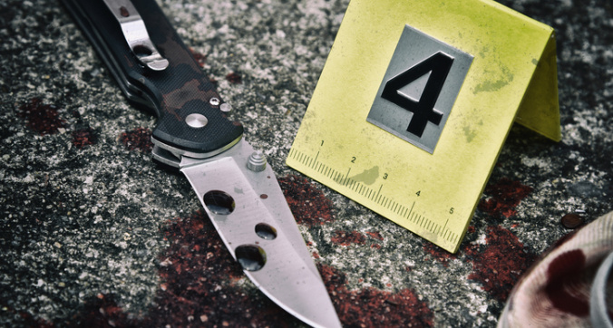 Crime scene investigation, Bloody knife and victim's shoes with criminal markers on ground