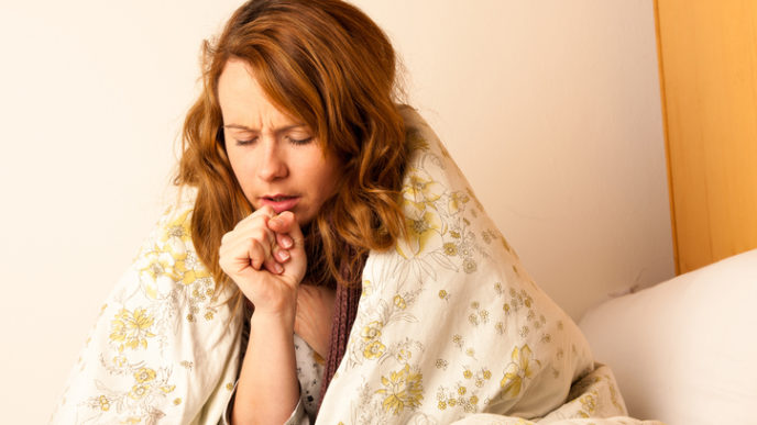 Sick woman cough in ved under blanket