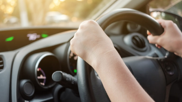 Woman's hands on car steering wheel