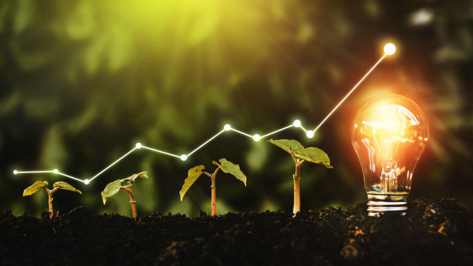 Lightbulb is located on the soil, and plant are growing.Renewable energy generation is essential in the future.