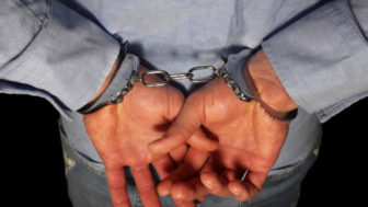 Handcuffs on arrested businessman hand