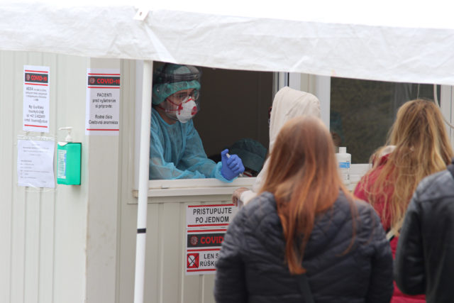Pacienti čakajú v rade pri kontajneri na testovanie výskytu ochorenia COVID-19 spôsobeného koronavírusom (2019-nCoV) pred Univerzitnou nemocnicou Bratislava  Nemocnicou akademika Ladislava Dérera. Bratislava, 20. marec 2020.