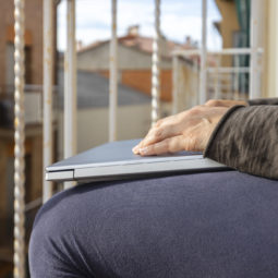 Woman with laptop on the balcony at home. Home office.