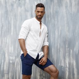 Handsome man in white shirt and shorts posing