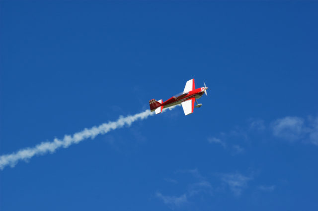 Model of acrobatic airplane flying in a blue sky