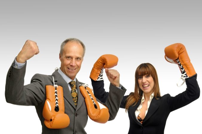 Business couple with boxing gloves isolated in white