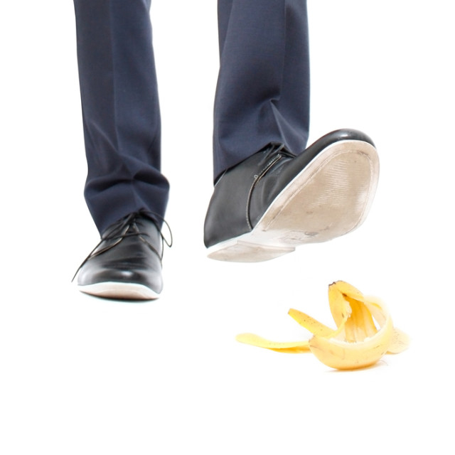 A banana peel and a man about to step in it