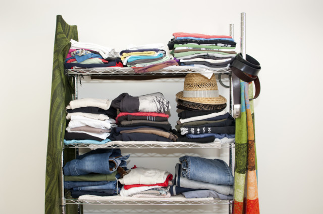 Clothes rack with stacked clothes for male and female, with jeans, tshirts, scarves, hats and more