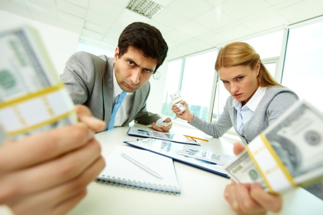 Image of angry employees with dollar bills in hands looking at you with aggression