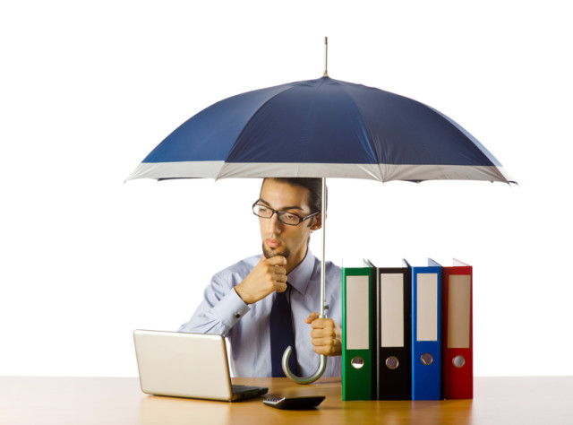 Businessman holding umbrella in the office