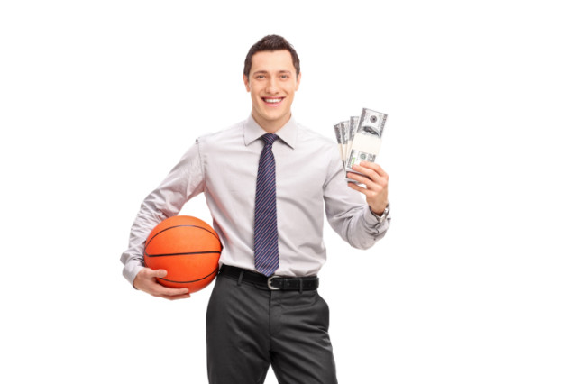 Businessman holding a basketball and money