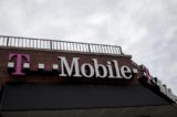 People pass by a T Mobile store in the Brooklyn borough of New York