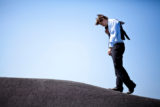 Businessman climbing an asphalt hill slouched