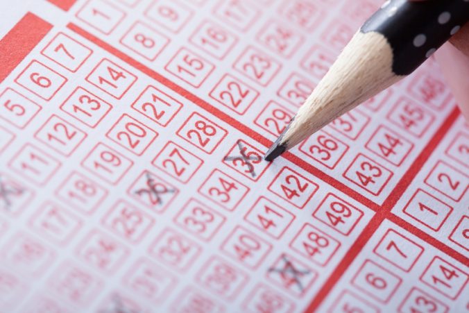 Person Marking Number On Lottery Ticket