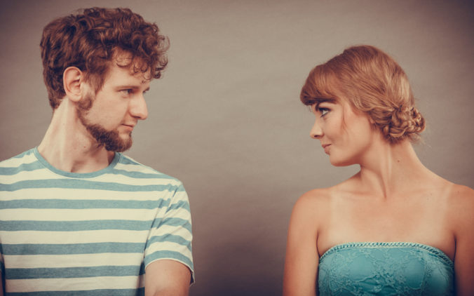 Woman and man sitting on sofa looking to each other.