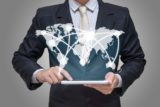 Businessman hand holding tablet global marketing on gray background