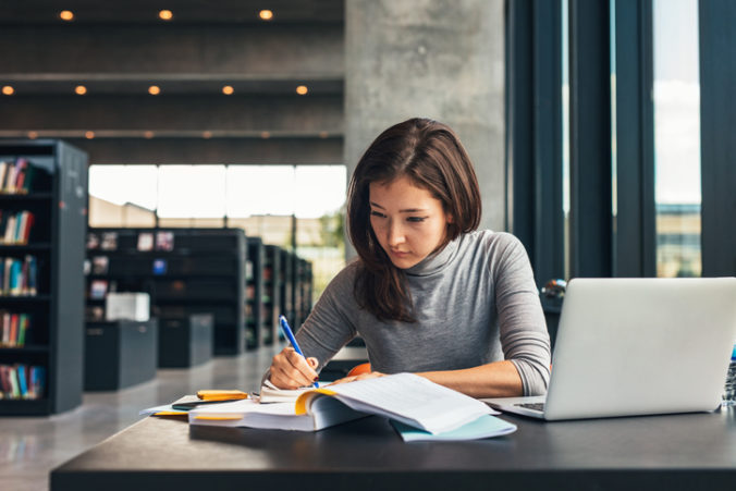 Female student studying at college library