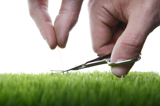 Young man cuts English lawn