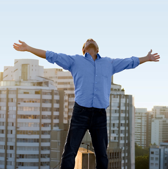 Man on roof with arms outstretched