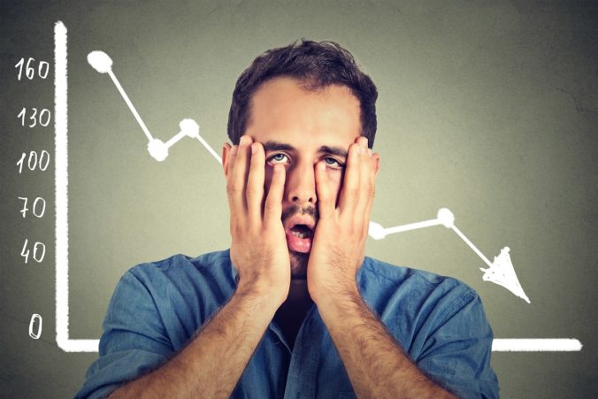 Frustrated stressed man desperate with financial market graphic going down