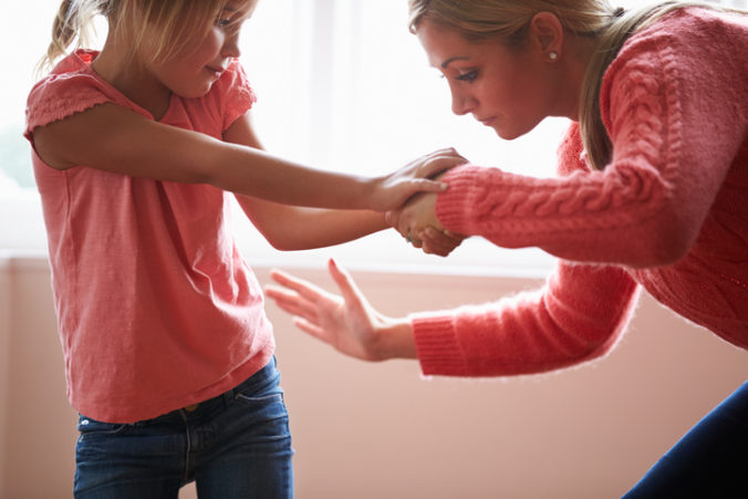 Mother in pink smacking young daughter