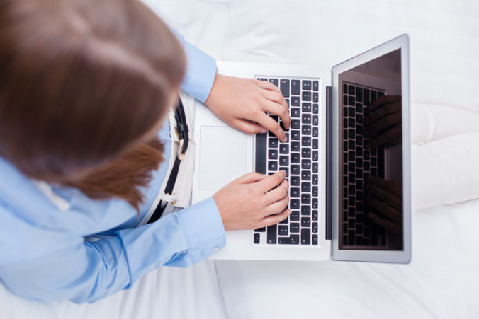 Close up view of hands using laptop