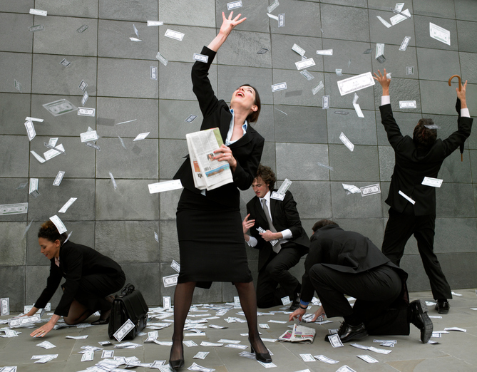 Business people on pavement catching falling money