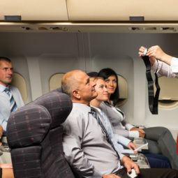 Flight attendant demo fastening seat belt airplane