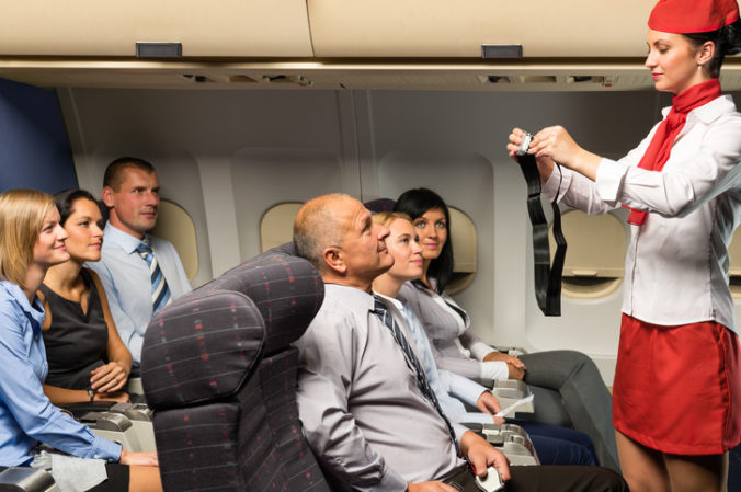 Flight attendant demo fastening seat belt airplane