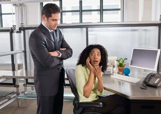 Boss catching businesswoman using cell phone