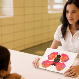 Teacher showing inkblot paintings to student