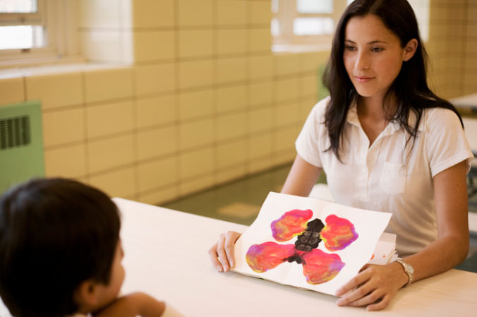 Teacher showing inkblot paintings to student