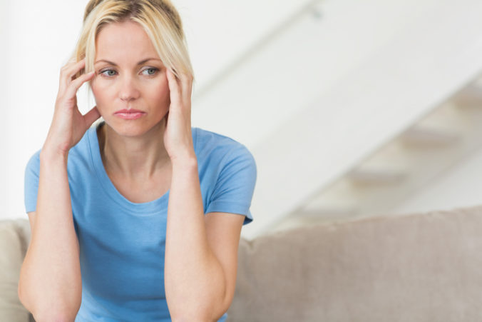 Worried young woman sitting in the living room