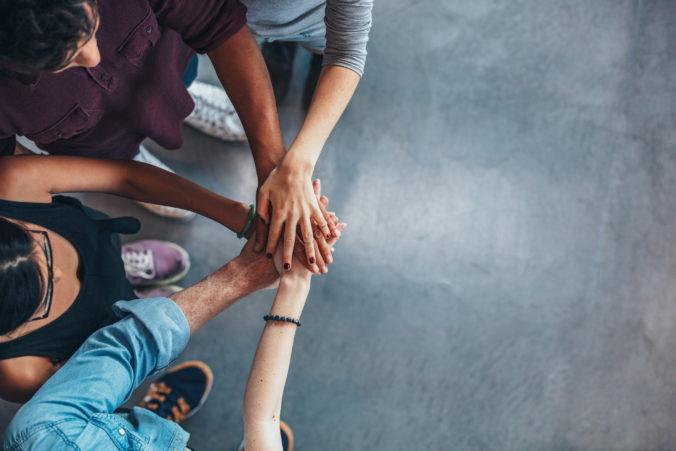 Group Of young people stacking their hands