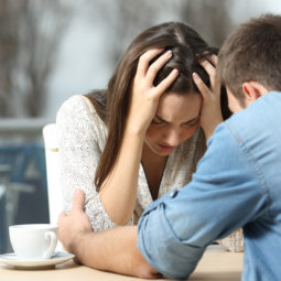 Man comforting a sad depressed girl