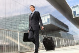 Businessman walking with trolley and bag, business travel