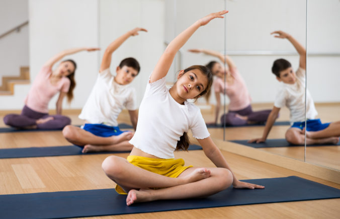Girl doing lotus pose exercises in gym