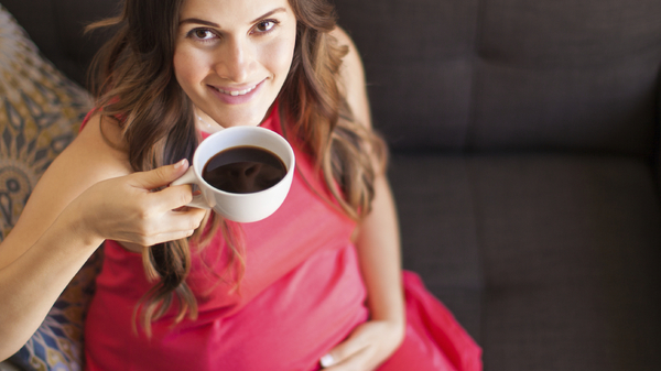 Happy pregnant woman with coffee