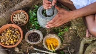 A young man preparing ayurvedic medicine in the traditional mann