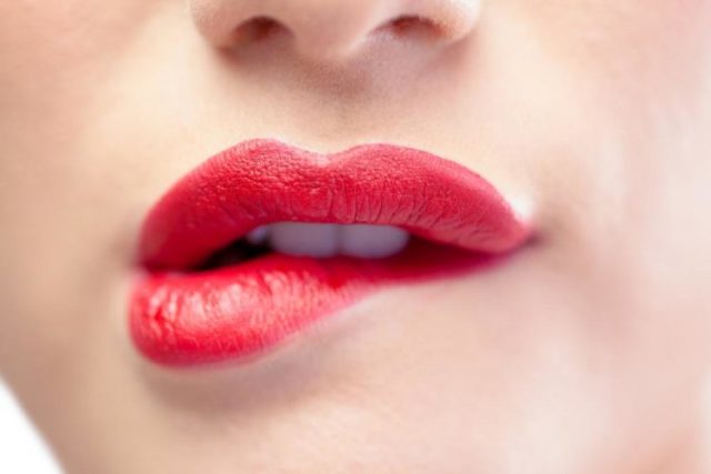 Close up on sensual model biting red lips e1506082244514.jpg