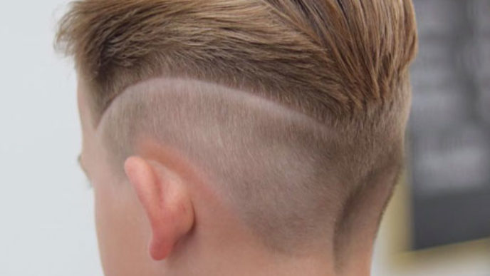 Slicked back hair with mid fade and design.jpg
