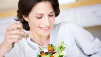 A woman eating a bowl of salad.jpg